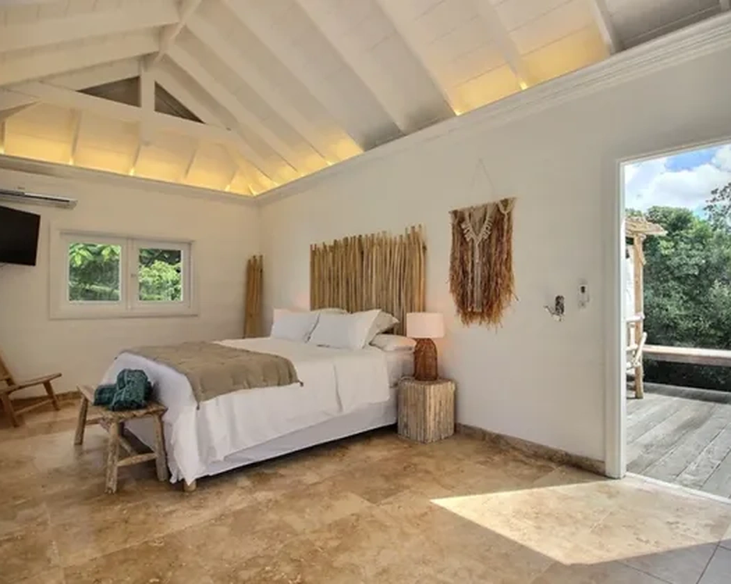 The bedroom opening onto the wooden terrace