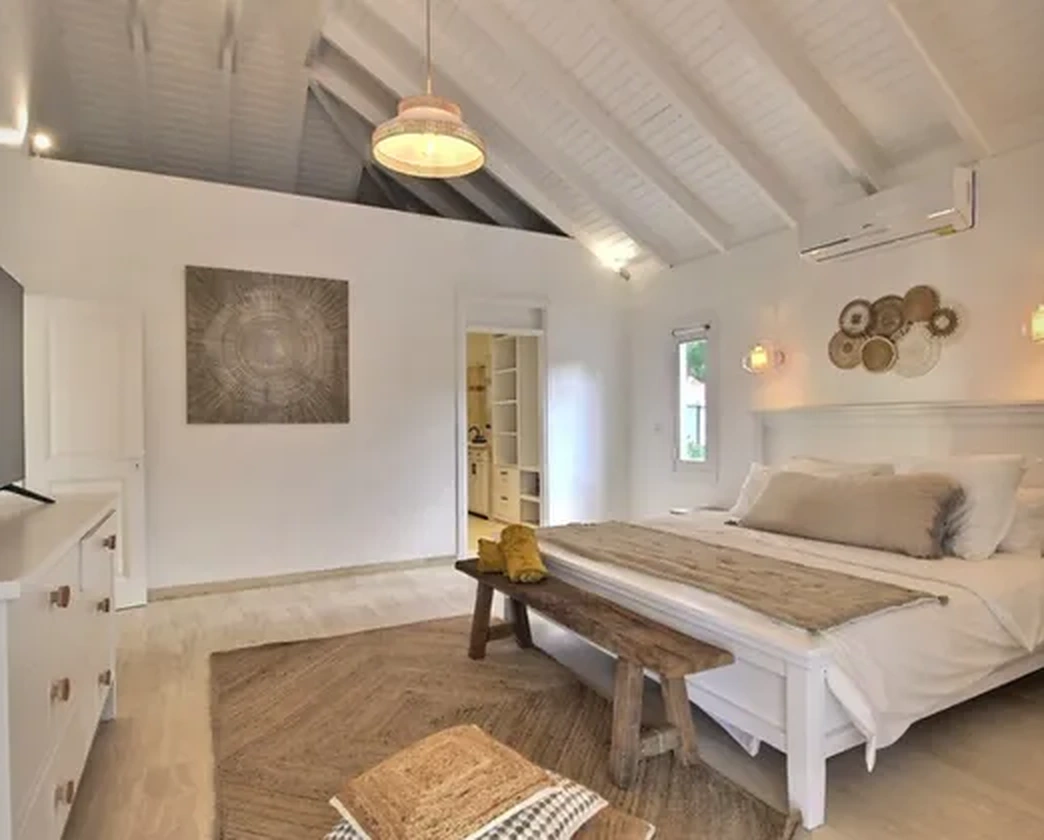 The bedroom beneath white roof beams